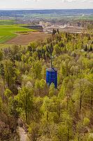 Dense green vegetation surrounds a blue water tower in a spring forest, Aidlingen, Böblingen district, Germany [IBR124642849]