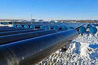 Storage of new gas pipes on an open-air site in the snow. Prepared drubs for laying an oil pipeline [IBR124748917]