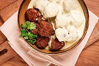 Swedish meatballs in cream sauce, plate on a wooden table, homemade, no people [IBR124748960]