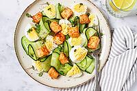 Delicious salmon and egg salad served on a plate with fresh cucumber and herbs for a healthy meal at lunchtime [IBR124748964]
