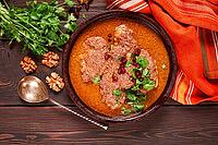 Fesenjan, an Iranian dish, stewed chicken, in walnut-pomegranate sauce, in an earthen pan, homemade, no people [IBR124748965]