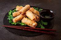 Pork nams, Vietnamese pancakes, rice paper stuffed, on black slate, with gnocchi sauce, no people [IBR124748996]