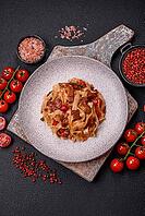 Food, Delicious asian udon dish with vegetables, meat, salt and spices on a ceramic plate on a dark concrete background [IBR124773703]