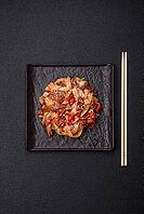 Food, Delicious asian udon dish with vegetables, meat, salt and spices on a ceramic plate on a dark concrete background [IBR124773709]