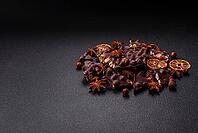 Food, Black bitter chocolate with whole hazelnuts, candied fruits and mint, broken into pieces on a dark concrete background [IBR124773723]