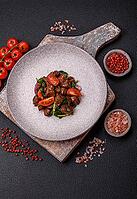 Food, Delicious warm salad with pieces of meat, spinach, tomatoes, salt, spices and herbs on a dark concrete background [IBR124773767]