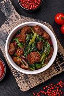 Food, Delicious warm salad with pieces of meat, spinach, tomatoes, salt, spices and herbs on a dark concrete background [IBR124773769]