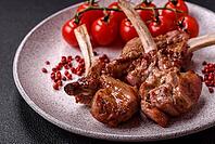 Food, Delicious juicy meat on the bone or rack of lamb or grilled veal with salt, spices and herbs [IBR124773774]