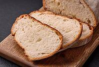 Food, A loaf of brown bread with grains of cereals on a wooden cutting board on a dark concrete background [IBR124773777]