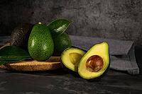 Delicious avocados in a cork plate on kitchen countertop [IBR124817848]