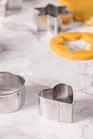 Raw dough for christmas cookies and cookie cutters on marble surface [IBR124817849]