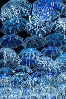 The beauty of white umbrellas iluminated by Christmas lights decorating the streets of Agueda Portugal [IBR124817850]
