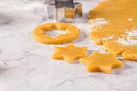 Raw dough for christmas cookies and cookie cutters on marble surface [IBR124817852]