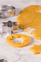 Raw dough for christmas cookies and cookie cutters on marble surface [IBR124817855]