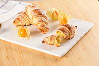 Small croissant with physalis fruits in white ceramic tray, homemade cakes on wooden table top [IBR124817865]