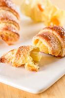 Small croissant with physalis fruits in white ceramic tray, homemade cakes on wooden table top [IBR124817870]