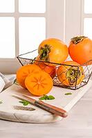 Delicious fresh persimmon fruit on kitchen countertop [IBR124817874]