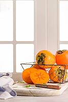 Delicious fresh persimmon fruit on kitchen countertop [IBR124817875]
