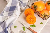 Delicious fresh persimmon fruit on kitchen countertop [IBR124817878]