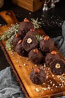 Dark chocolate truffles with hazelnuts over wooden cutting board [IBR124817894]