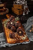 Dark chocolate truffles with hazelnuts over wooden cutting board [IBR124817895]