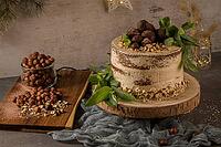 Delicious naked coffee and hazelnuts cake on table rustic wood kitchen countertop [IBR124817896]