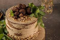 Delicious naked coffee and hazelnuts cake on table rustic wood kitchen countertop [IBR124817900]