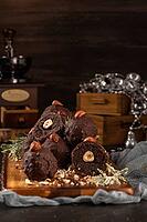 Dark chocolate truffles with hazelnuts over wooden cutting board [IBR124817906]