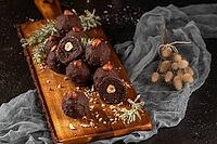 Dark chocolate truffles with hazelnuts over wooden cutting board [IBR124817908]
