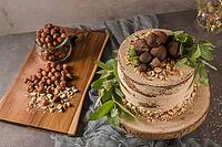 Delicious naked coffee and hazelnuts cake on table rustic wood kitchen countertop [IBR124817935]