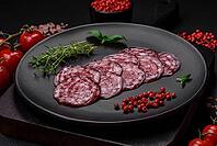 Food, Delicious smoked sausage with bacon, salt, spices and herbs cut into slices on a wooden cutting board [IBR124842014]