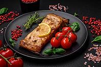 Food, Slice of delicious baked fish with salt, spices and herbs on a ceramic plate on a dark concrete background [IBR124842032]