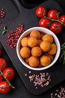 Food, Delicious fried potato balls with breaded mozzarella, salt, spices and herbs on a dark concrete background [IBR124842038]