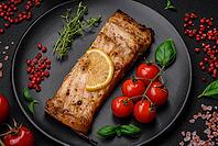 Food, Slice of delicious baked fish with salt, spices and herbs on a ceramic plate on a dark concrete background [IBR124842046]