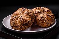 Food, Delicious freshly baked crispy bun or kaiser roll with sesame seeds on dark concrete background [IBR124842048]