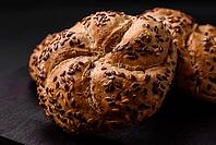 Food, Delicious freshly baked crispy bun or kaiser roll with sesame seeds on dark concrete background [IBR124842050]