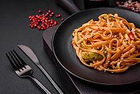 Food, Delicious asian udon dish with vegetables, mushrooms, salt and spices on a ceramic plate on a dark concrete background [IBR124842057]