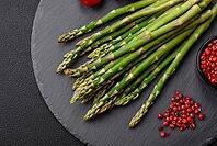 Food, Delicious fresh sprigs of asparagus on a dark textured background. Ingredients for a healthy vegetarian meal [IBR124842071]