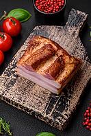 Food, Delicious calorie smoked bacon with salt, spices and herbs on a dark concrete background [IBR124842079]
