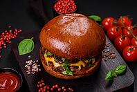 Food, Burger with juicy beef cutlet, cheese, tomatoes, salt, spices and herbs on a dark concrete background [IBR124842082]