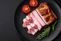 Food, Delicious calorie smoked bacon with salt, spices and herbs on a dark concrete background [IBR124842085]
