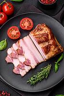 Food, Delicious calorie smoked bacon with salt, spices and herbs on a dark concrete background [IBR124842100]