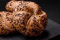 Food, Delicious freshly baked crispy bun or kaiser roll with sesame seeds on dark concrete background [IBR124842110]