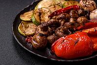 Grilled vegetables, bell peppers, mushrooms, and zucchini, a vegetarian healthy meal with sauce. Grilled vegetables on a plate as a food background for your design [IBR124865238]