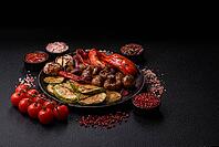 Grilled vegetables, bell peppers, mushrooms, and zucchini, a vegetarian healthy meal with sauce. Grilled vegetables on a plate as a food background for your design [IBR124865250]