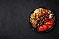 Grilled vegetables, bell peppers, mushrooms, and zucchini, a vegetarian healthy meal with sauce. Grilled vegetables on a plate as a food background for your design [IBR124865253]
