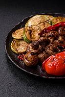 Grilled vegetables, bell peppers, mushrooms, and zucchini, a vegetarian healthy meal with sauce. Grilled vegetables on a plate as a food background for your design [IBR124865254]