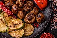 Grilled vegetables, bell peppers, mushrooms, and zucchini, a vegetarian healthy meal with sauce. Grilled vegetables on a plate as a food background for your design [IBR124865256]