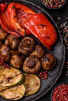Grilled vegetables, bell peppers, mushrooms, and zucchini, a vegetarian healthy meal with sauce. Grilled vegetables on a plate as a food background for your design [IBR124865260]