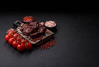 Beef, grilled meat in pieces, or kebab with sauce and vegetables. Beef in pieces as a food background for your design [IBR124865275]